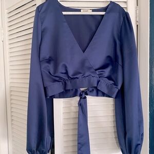 Blue silk cropped top with tie back and long sleeves.